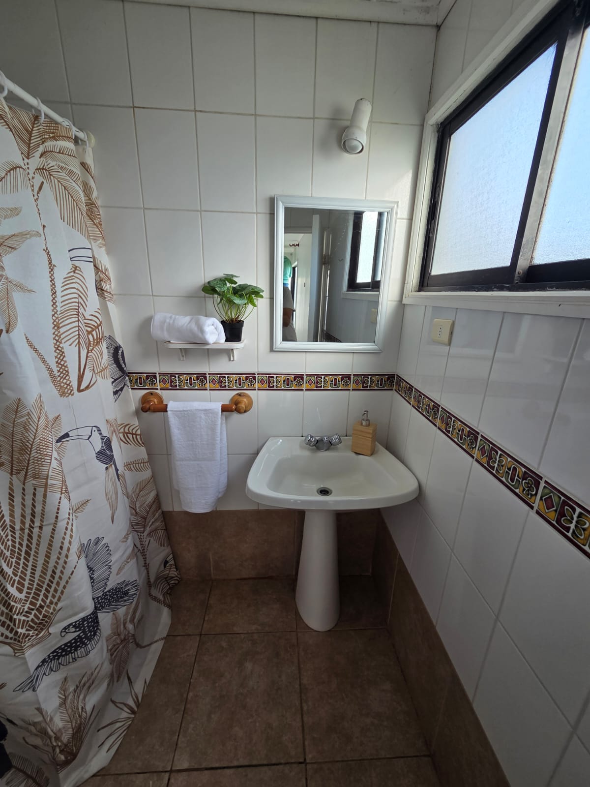 Baño del hostal con ventana y detalles cerámicos